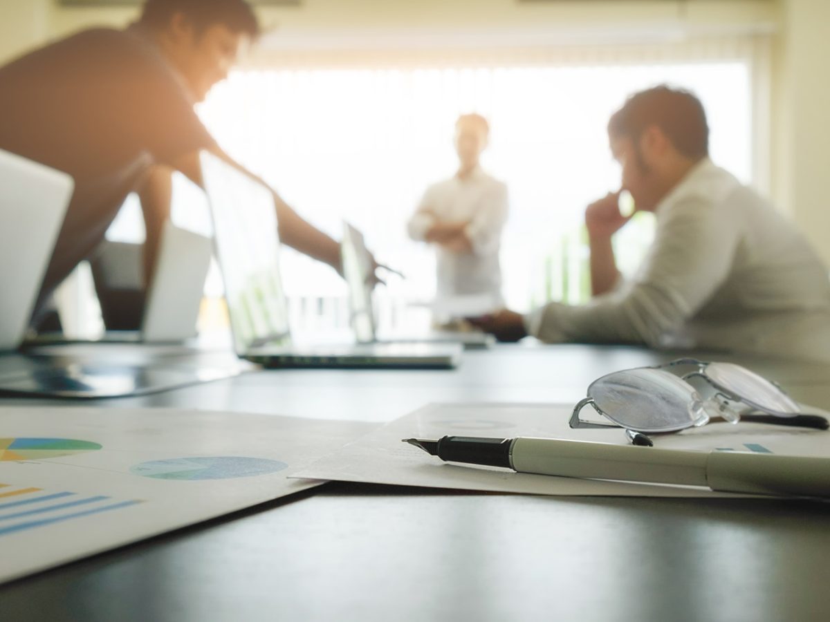 Business concept with copy space. Office desk table with pen focus and analysis chart, computer, notebook, cup of coffee on desk.Vintage tone Retro filter, selective focus.